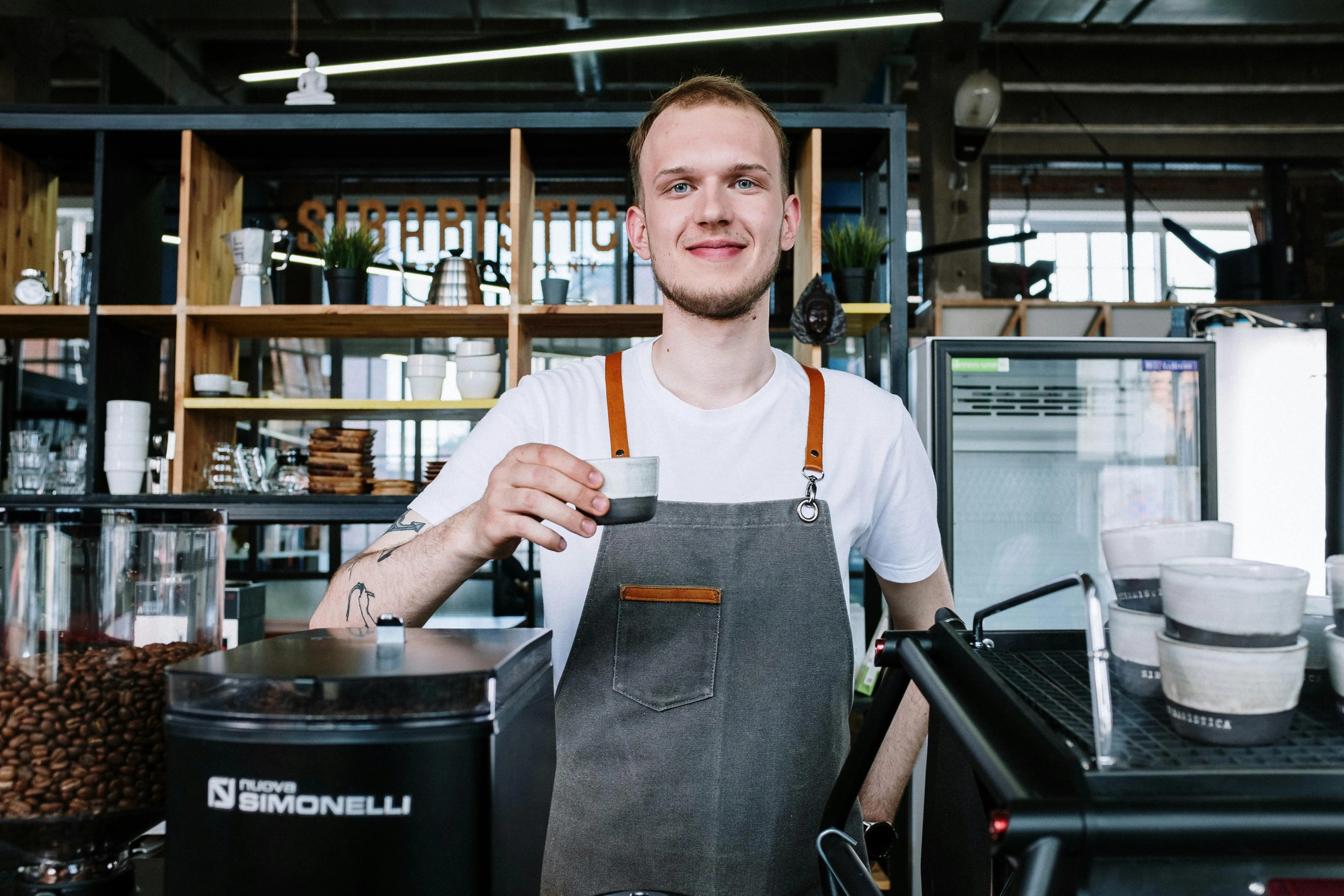 A barista holding up a coffee